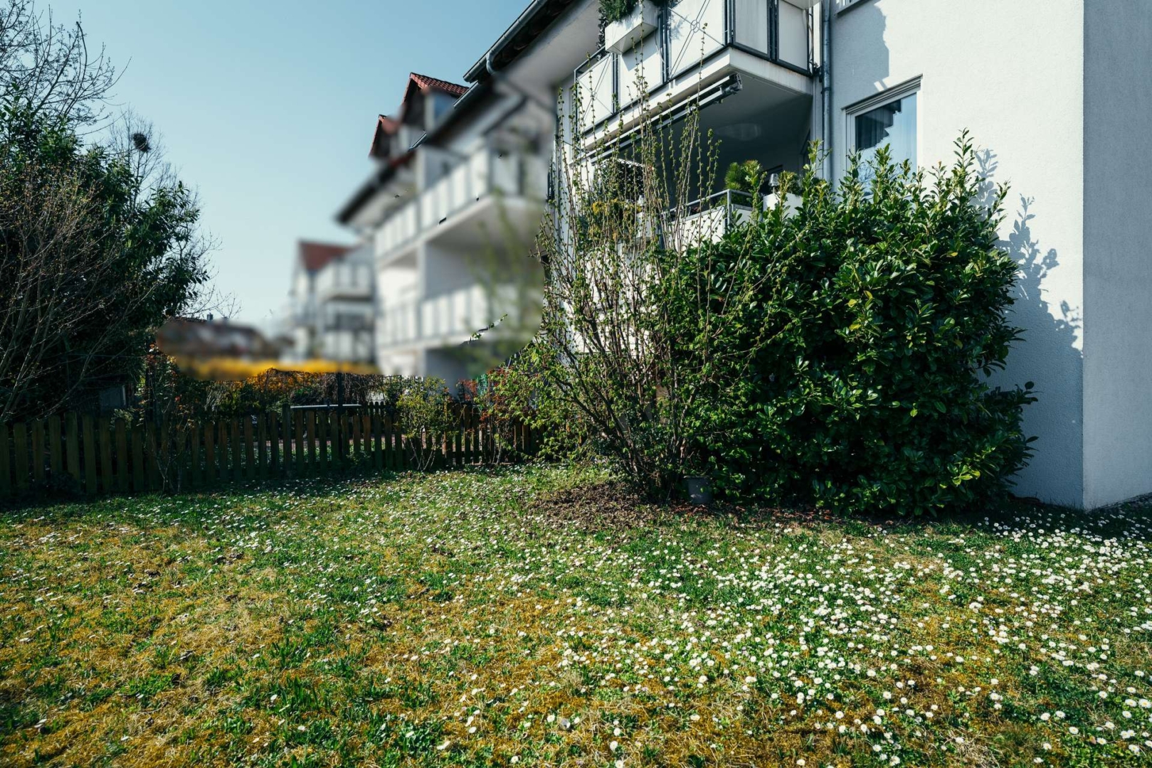 Weitere Außenansicht des Gebäudes mit Vorgarten und Zaun