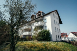 Außenansicht des Hauses mit Balkonen, Vorgarten und gewachsenem Umfeld