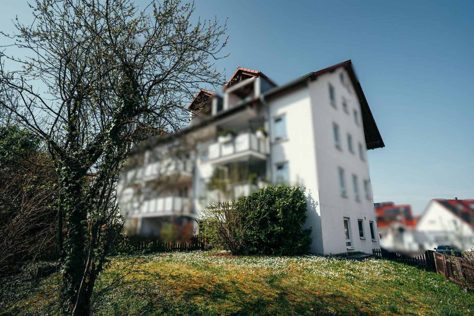 Außenansicht des Hauses mit Balkonen, Vorgarten und gewachsenem Umfeld