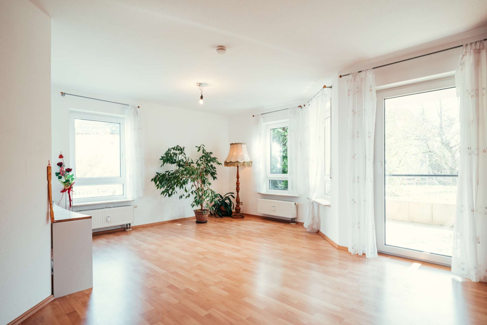 Helles Wohnzimmer mit großer Fensterfront und direktem Zugang nach außen