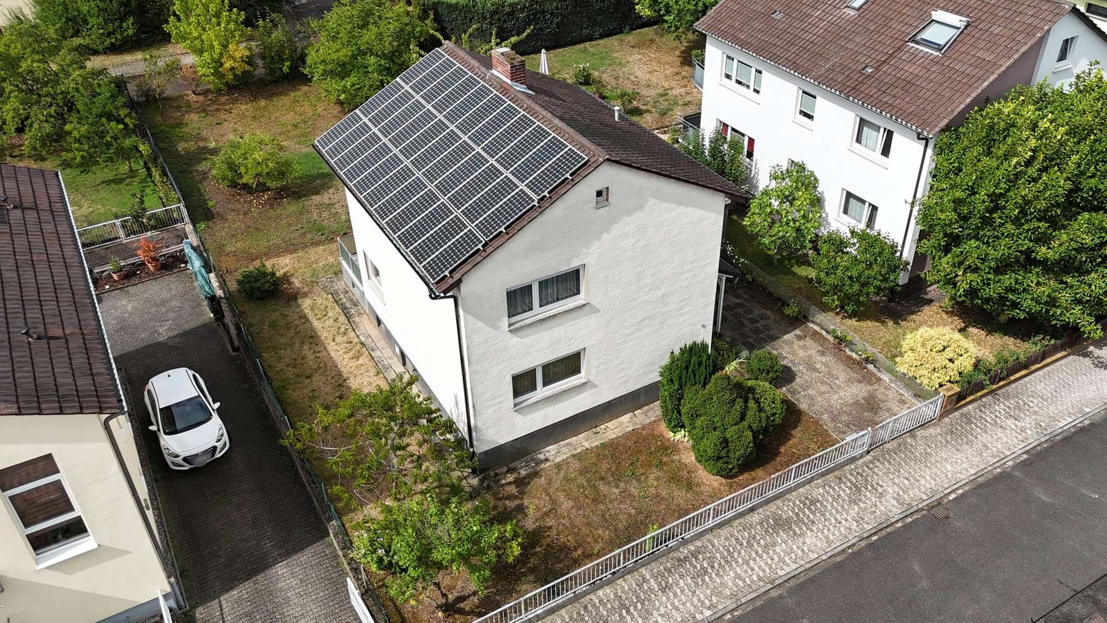 Luftaufnahme mit Blick auf Haus, Grundstück und Photovoltaikanlage