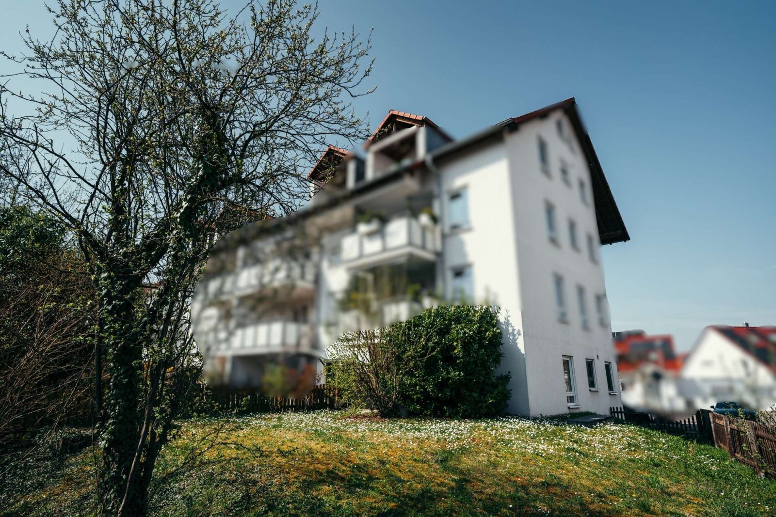 Außenansicht des Hauses mit Balkonen, Vorgarten und gewachsenem Umfeld