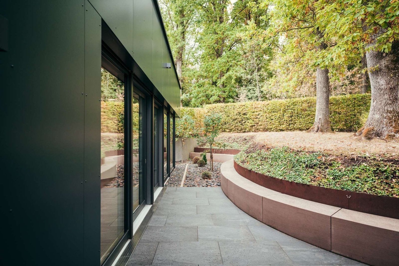 Terrasse mit Sandstein-Sitzbank und Gartenbezug